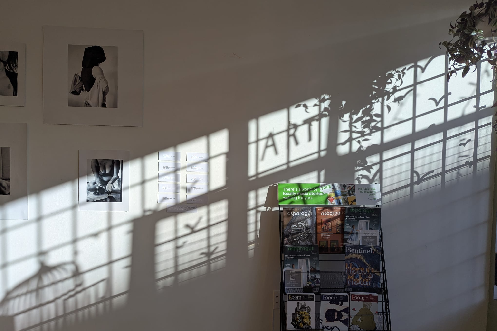 Light casting shadow on the gallery wall, featuring the word "ART"